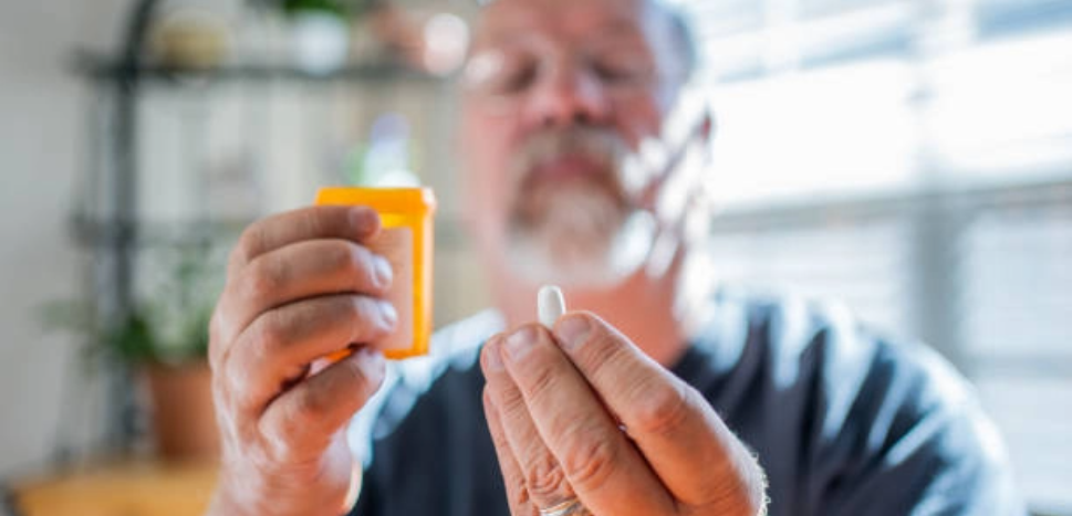 man determining blood donation requirements and examining pill